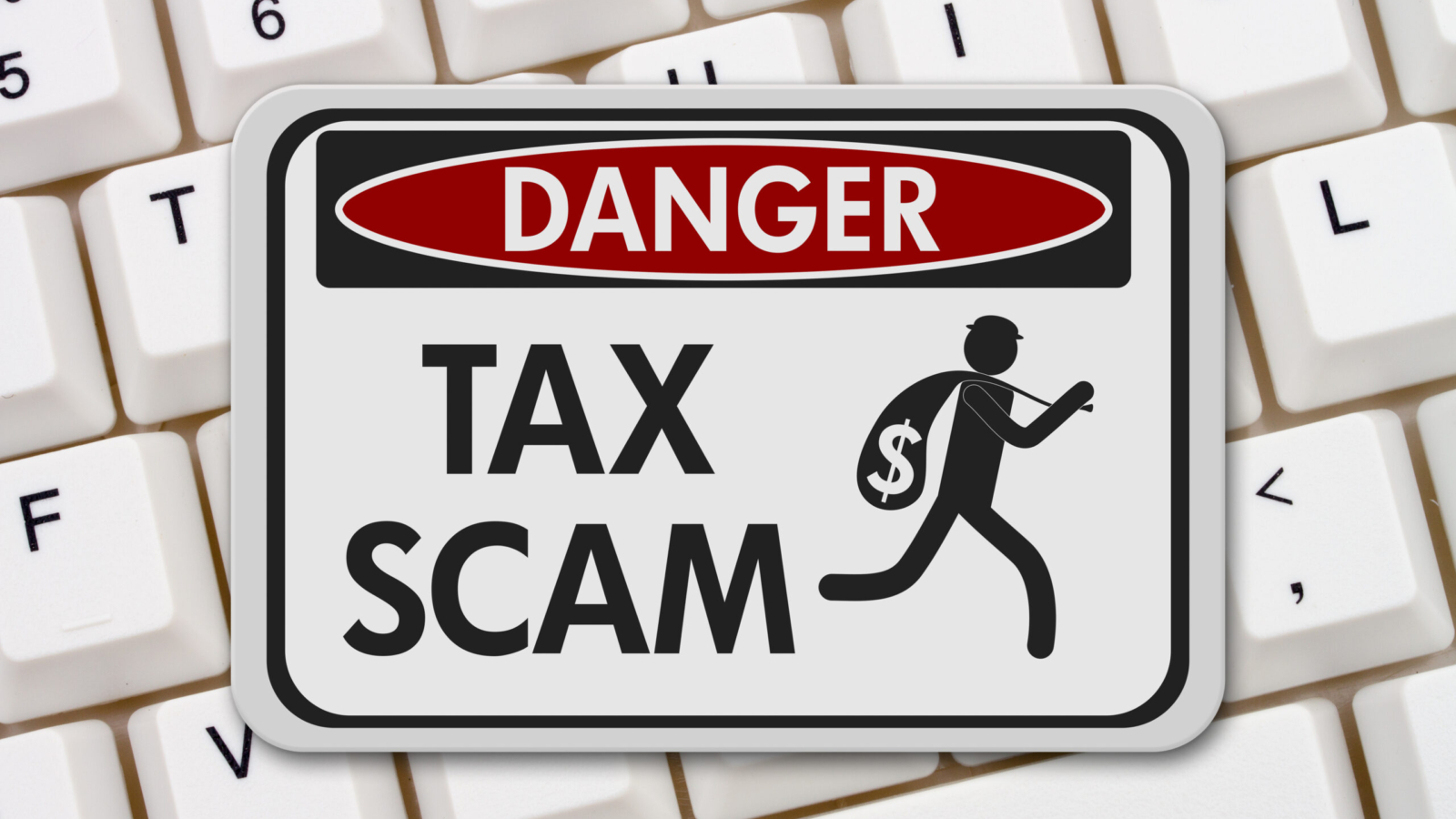 Tax scam danger sign, A black and white danger sign with text Tax Scam and theft icon on a keyboard