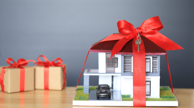 Real estate and Gift new home concept,Model house with Red ribbon and key on black background