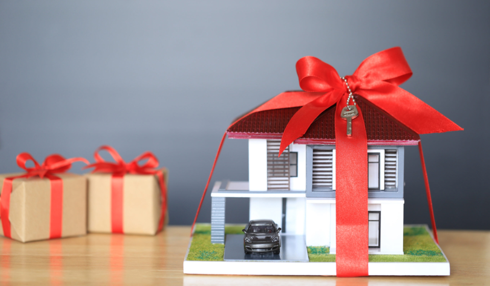 Real estate and Gift new home concept,Model house with Red ribbon and key on black background