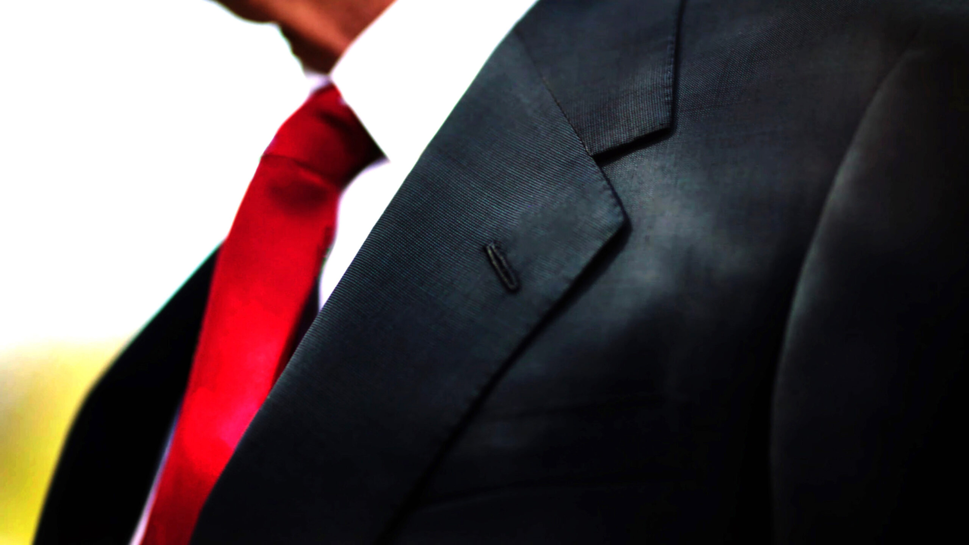 a black business suit jacket with white shirt and red tie, man n